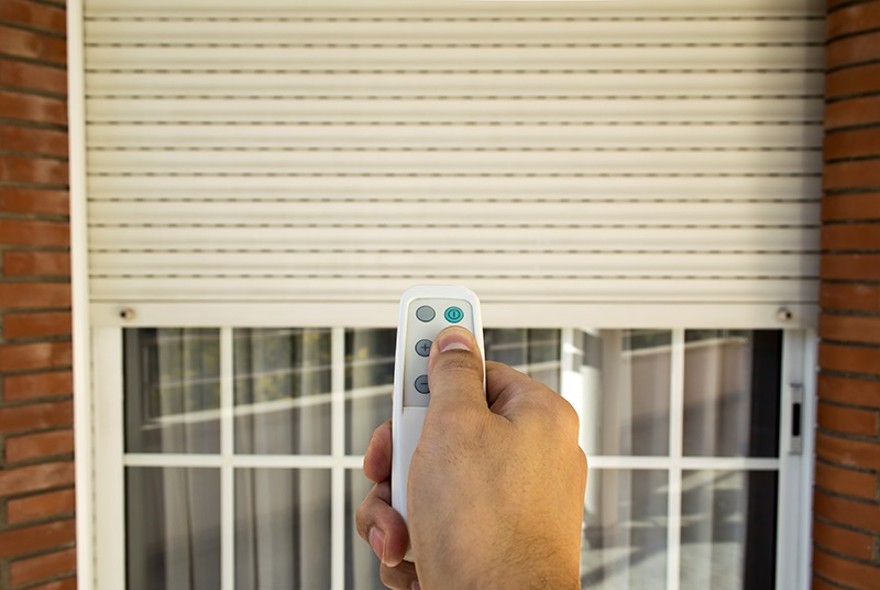 hand holding remote in front of a window