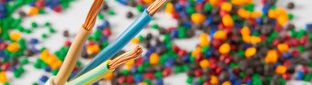 Plastic coated wire cable with plastic polymer granules in the background