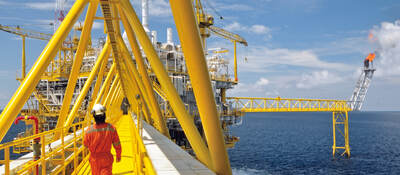 A worker walking on a platform of an offshore rig. 