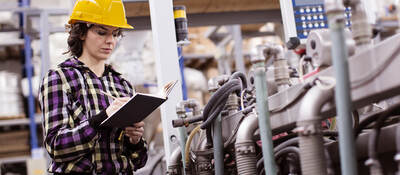 female engineer inspects industrial equipment