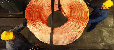 Workers moving roll of copper wire.