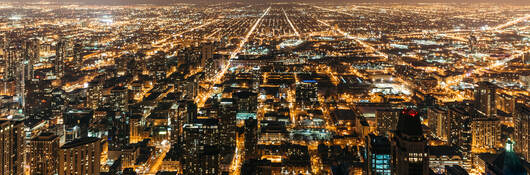 Cityscape at night with many lights from homes, businesses, roads