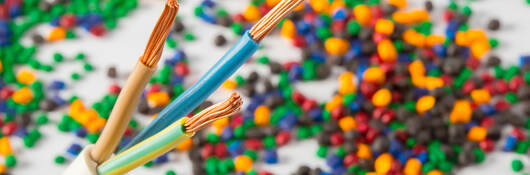 Plastic coated wire cable with plastic polymer granules in the background