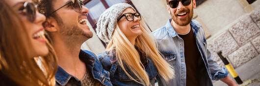 Men and women wearing different types of eyewear walking down a city street