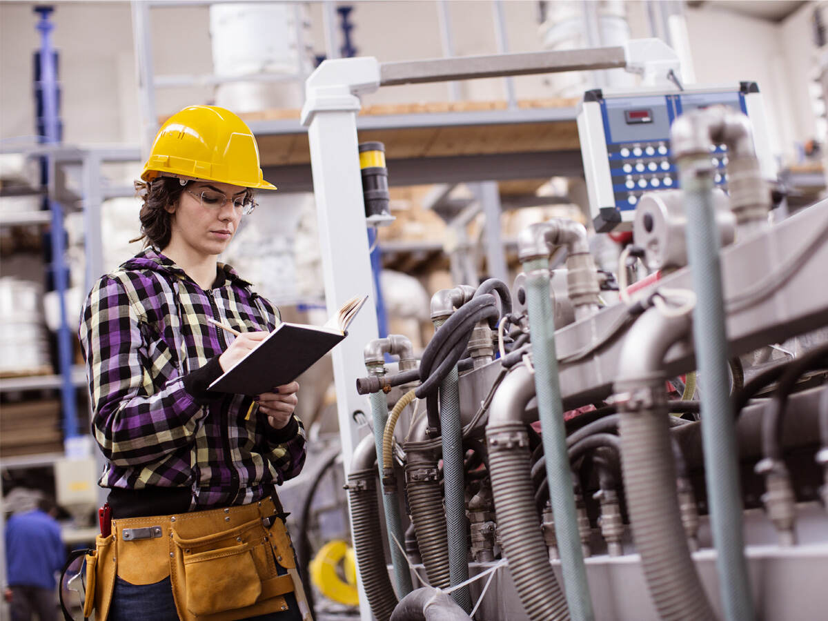 female engineer inspects industrial equipment