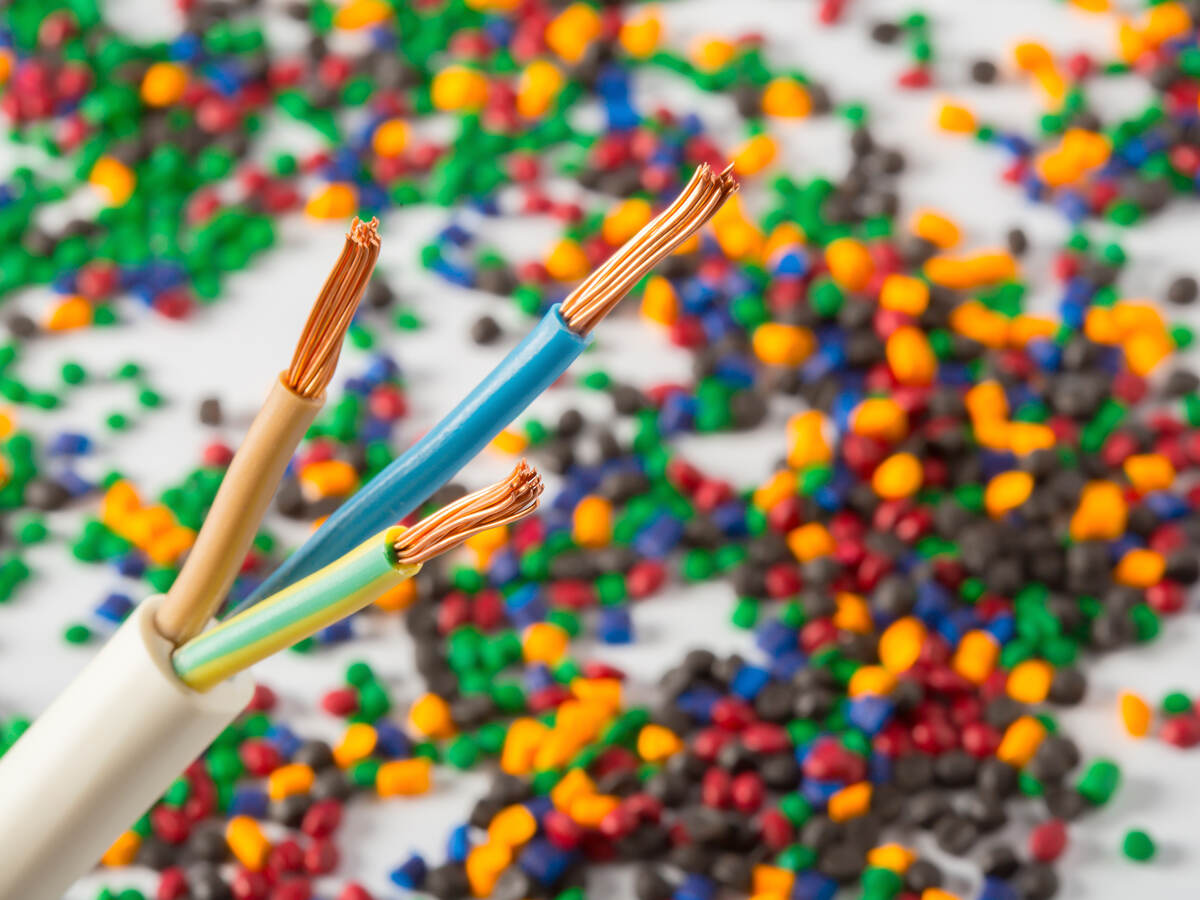 Plastic coated wire cable with plastic polymer granules in the background