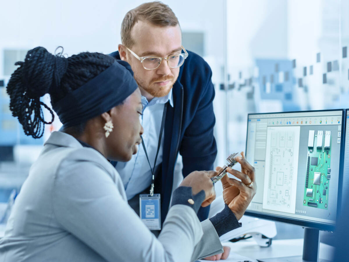 Colleagues discuss microchips in engineering workspace 