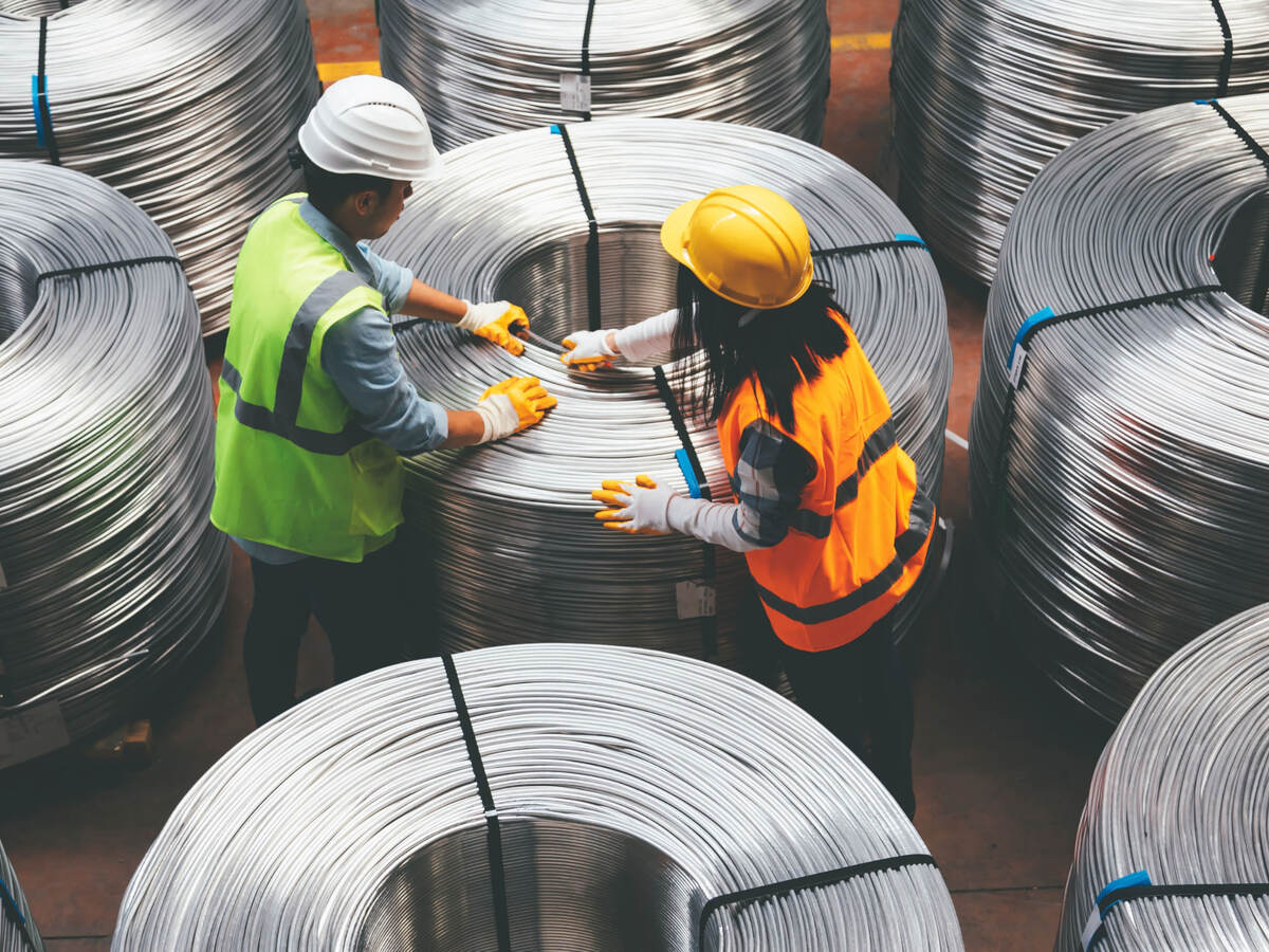 People working with large spools of wire in a warehouse