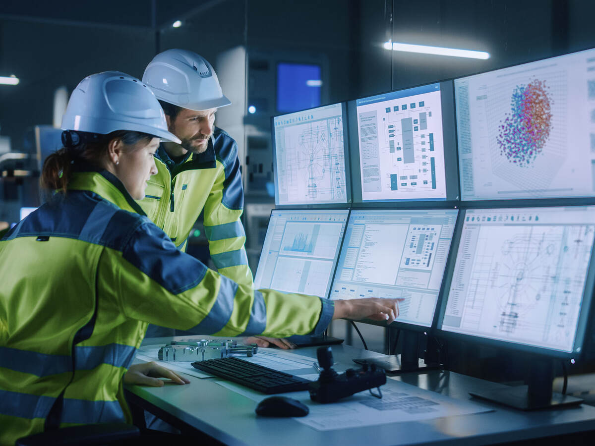 Project engineer talks to female operator who controls facility production line.