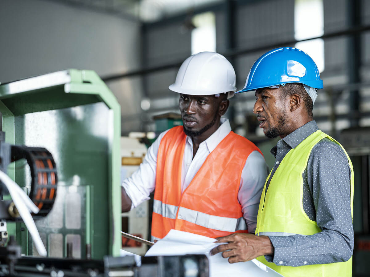 African Businessmen and Production Manager during meeting with production scheduling plan in a factory.