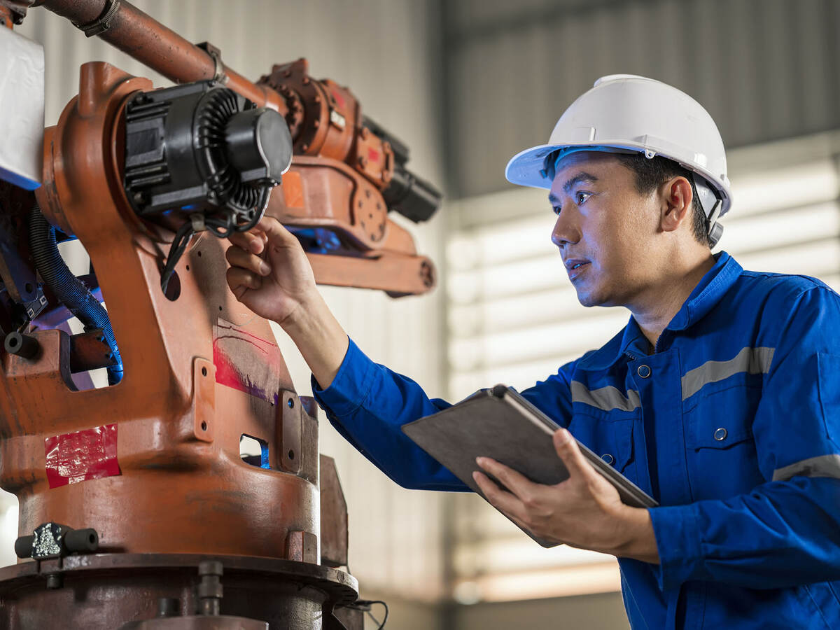 Senior Engineer testing of an industrial robot accuracy and repeatability in off and online by using digital tablet.