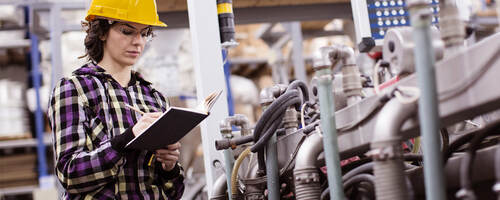female engineer inspects industrial equipment